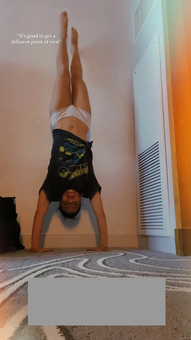 María Gabriela de Faría balancing barefoot in a handstand.