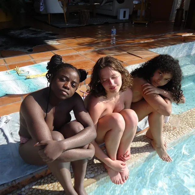 Whitney Peak sitting barefoot beside friends at a pool edge.