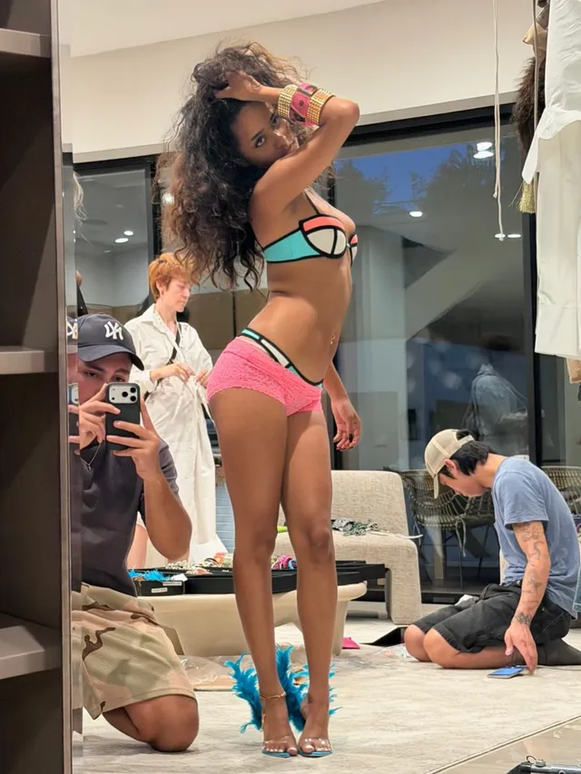 Tyla posing on a set in heeled sandals and colourful swimwear.