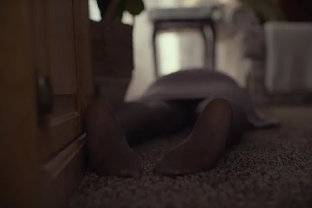 Daisy Ridley lying on a floor in a dramatic screen scene.