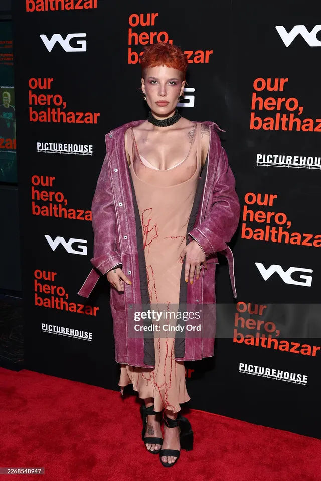 Halsey a pink coat and black heels on red carpet.