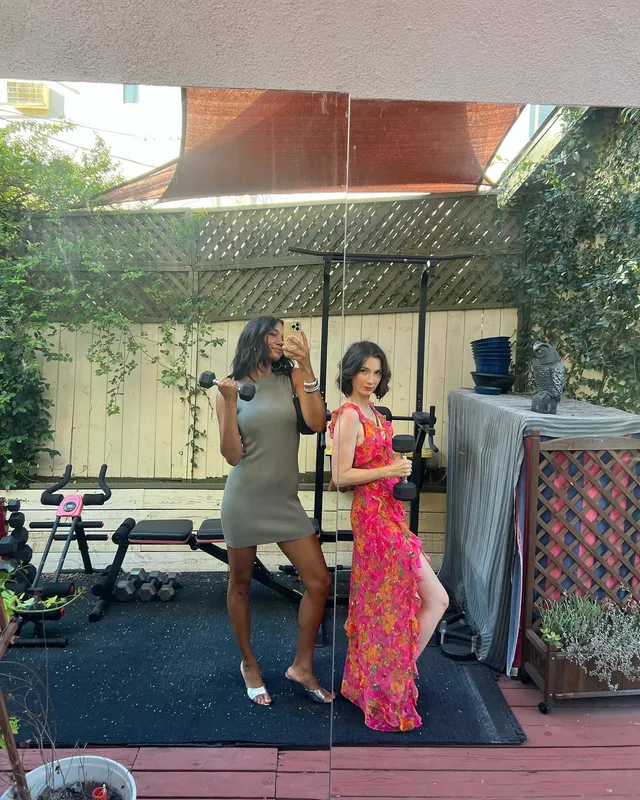 Greta Onieogou posing with a friend outdoors in a pale dress and white heels.