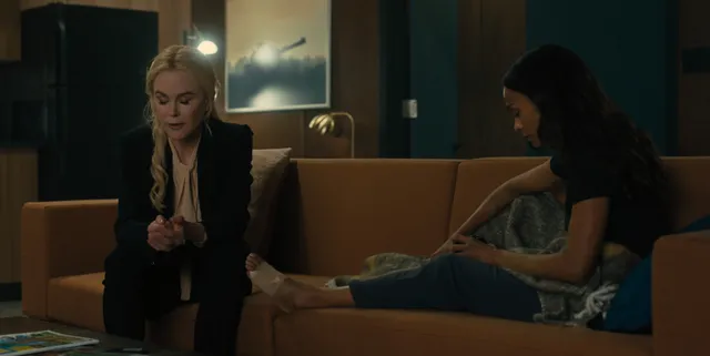 Zoe Saldaña sitting with another woman in a screen scene.