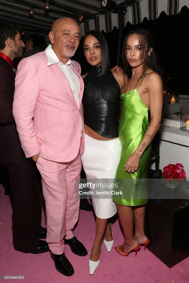 Zoë Kravitz posing with guests in a white skirt.