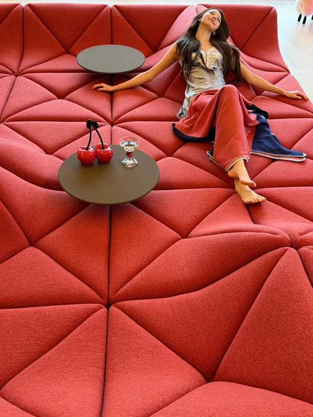 Jang Wonyoung reclining barefoot on a red sofa.
