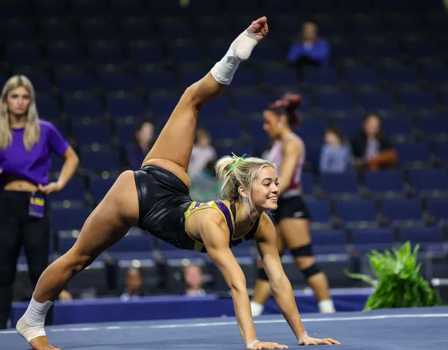 Olivia Dunne performing a floor routine with ankle wraps and bare toes.