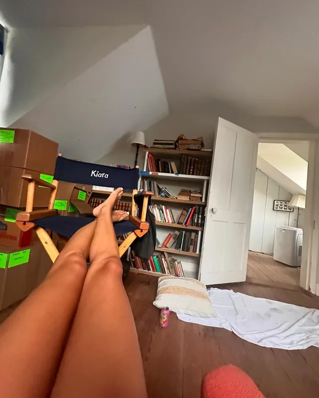 Madison Bailey reclining with bare feet raised in a room.
