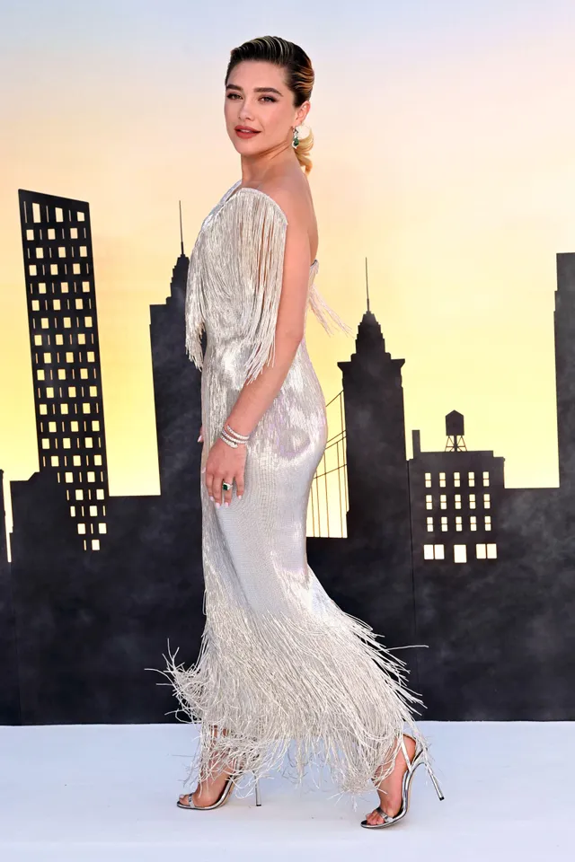 Florence Pugh posing in a silver gown and heels at a premiere.