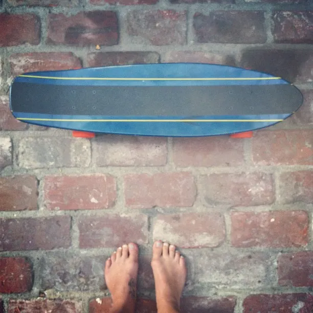 Melissa Benoist a close detail of bare feet on a brick surface.