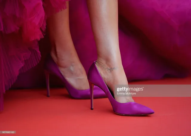 Deepika Padukone showing pink pointed heels on a red carpet.