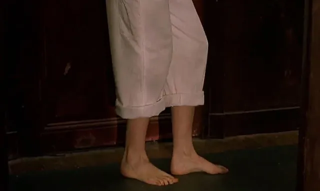 Eva Green a screen detail of bare feet beneath pale trousers.
