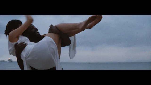 Gemma Chan being lifted beside the sea in a screen scene.