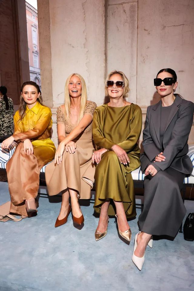Hayley Atwell sitting with other guests in tailored outfits.
