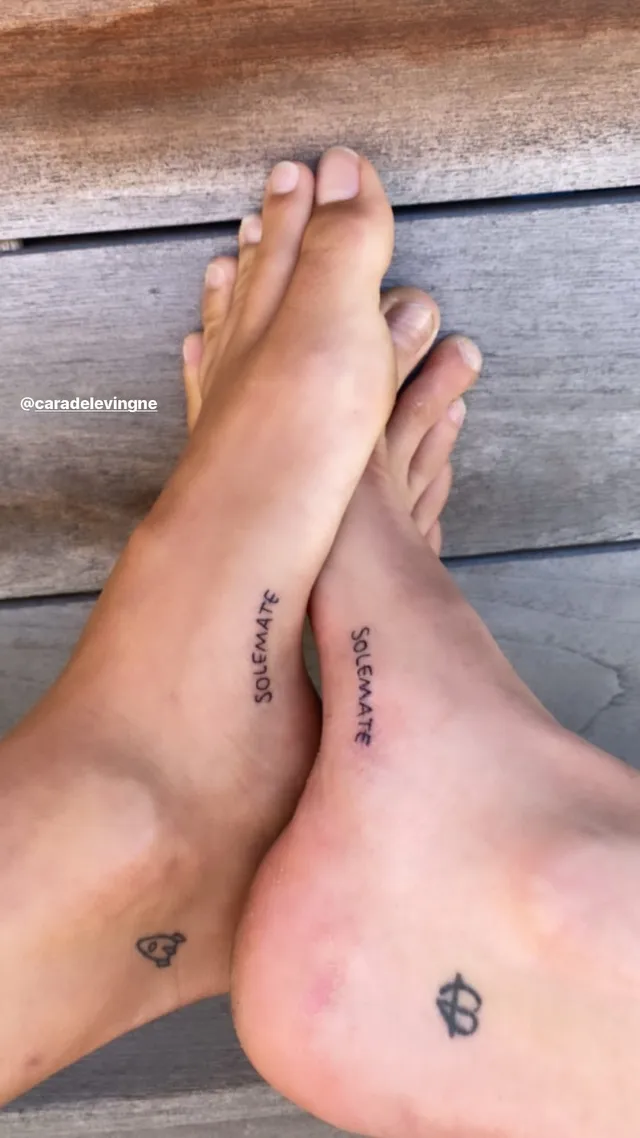 Cara Delevingne resting her feet with tattoos visible.