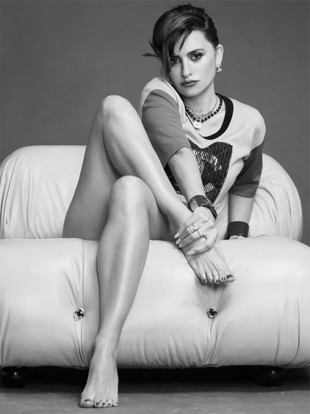 Penélope Cruz a monochrome sofa portrait in a graphic shirt.
