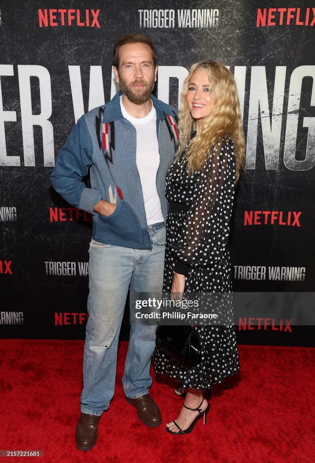 Teresa Palmer posing with a companion at a premiere.
