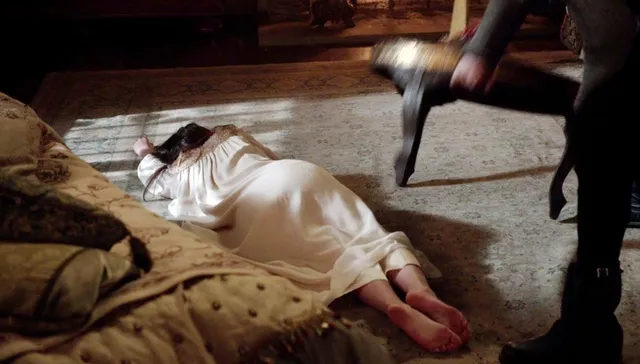 Adelaide Kane lying on a rug during a screen scene.