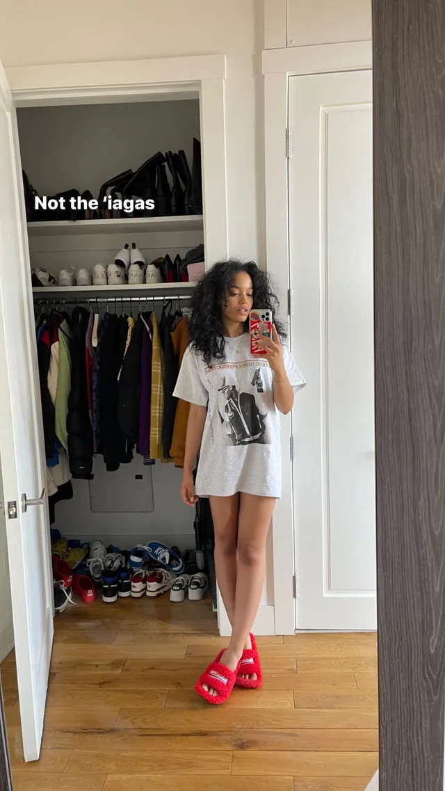 Whitney Peak taking a mirror selfie in a T-shirt and red slides.