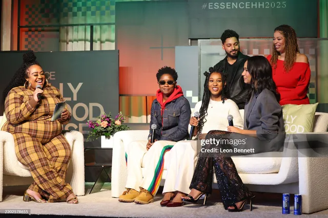 Greta Onieogou sitting with fellow performers onstage in a grey blazer and lace trousers.