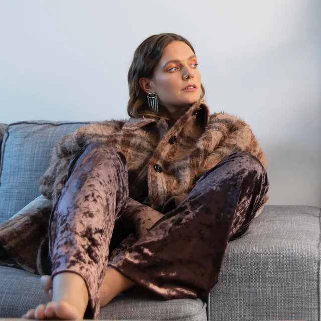 Tove Lo sitting on a sofa with a bare foot visible.