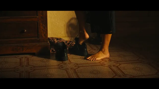 Adèle Exarchopoulos standing beside shoes in a screen scene.