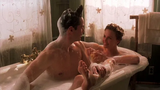 Charlize Theron a bathtub screen scene beside another character.