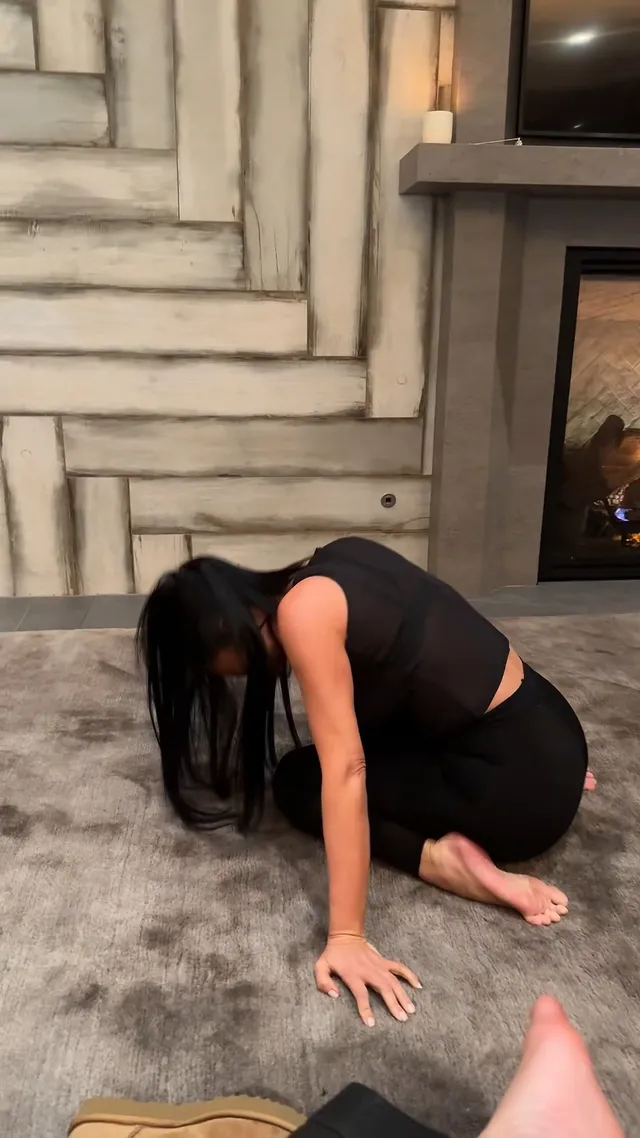 Kim Kardashian: kneeling barefoot beside a swimming pool.