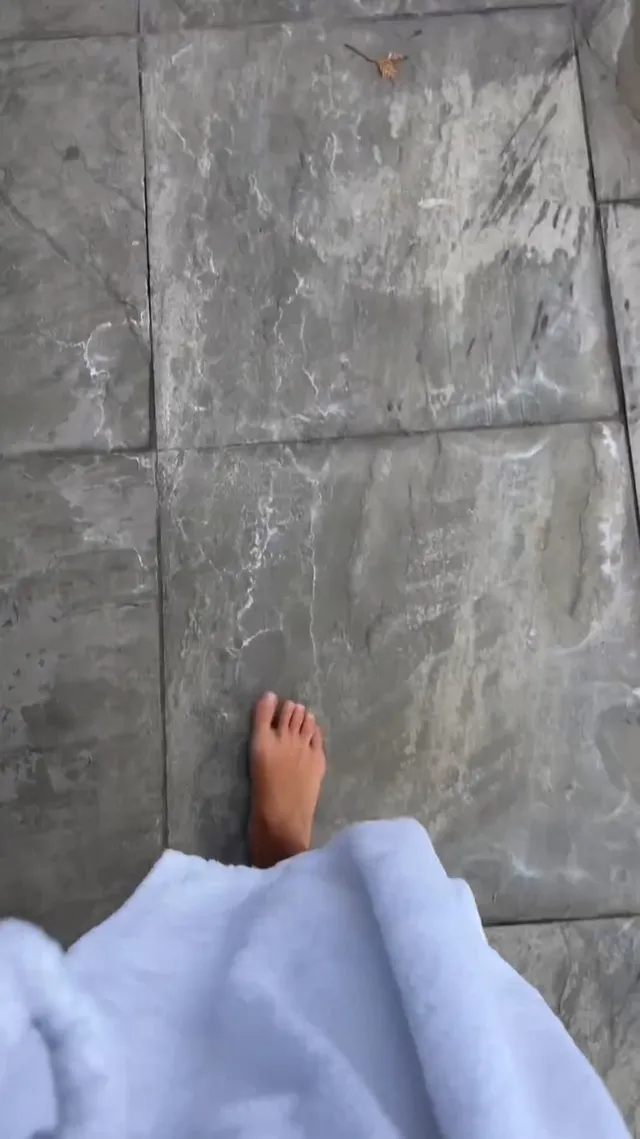 Kiana Madeira shown stepping barefoot on a stone floor.
