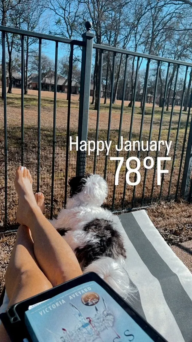 Brec Bassinger reclining barefoot outside with a dog nearby.