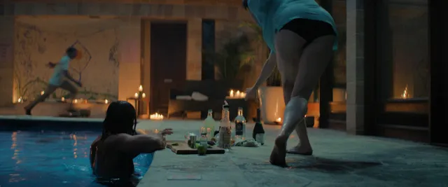Daisy Ridley standing beside a pool in a dramatic screen scene.