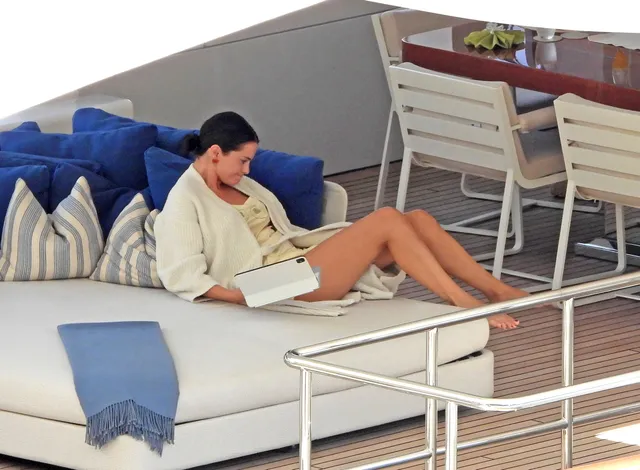Selena Gomez sitting on a boat and looking down.