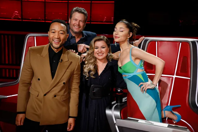 Ariana Grande posing beside guests in a television studio.