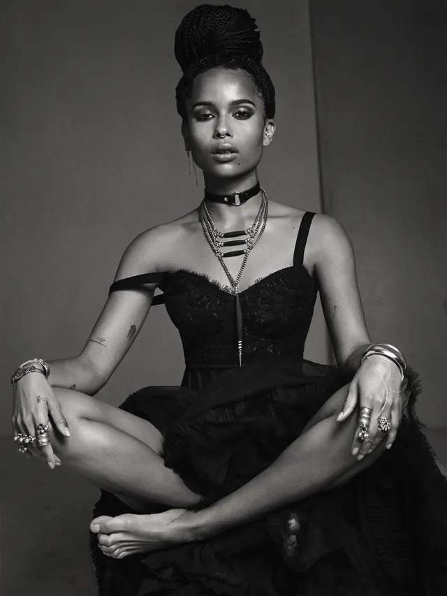 Zoë Kravitz sitting cross legged in a monochrome fashion portrait.