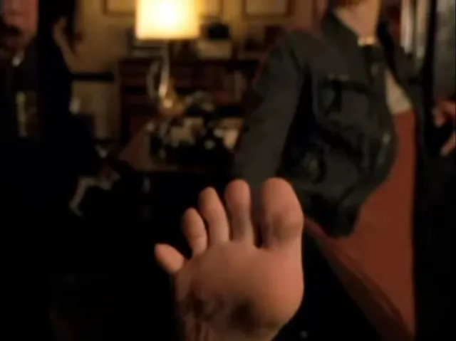 Kristen Bell with a bare sole visible beside a shoe in a screen image.