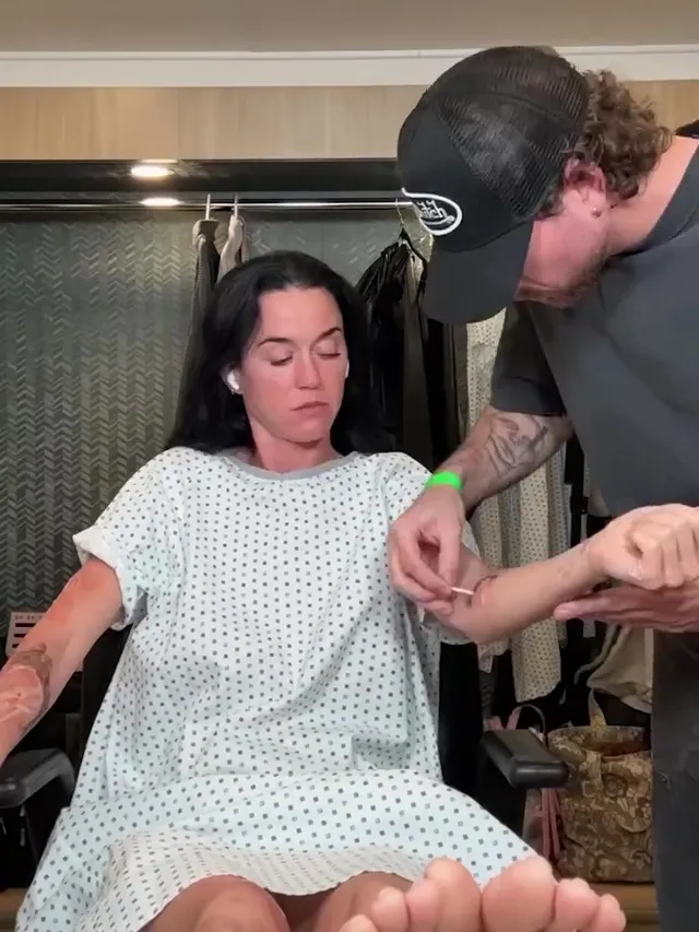 Katy Perry showing bare soles while seated in a makeup chair.