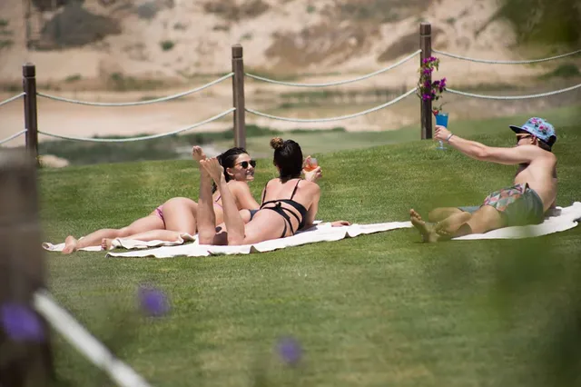 Danielle Campbell sitting with companions on a grassy bank.