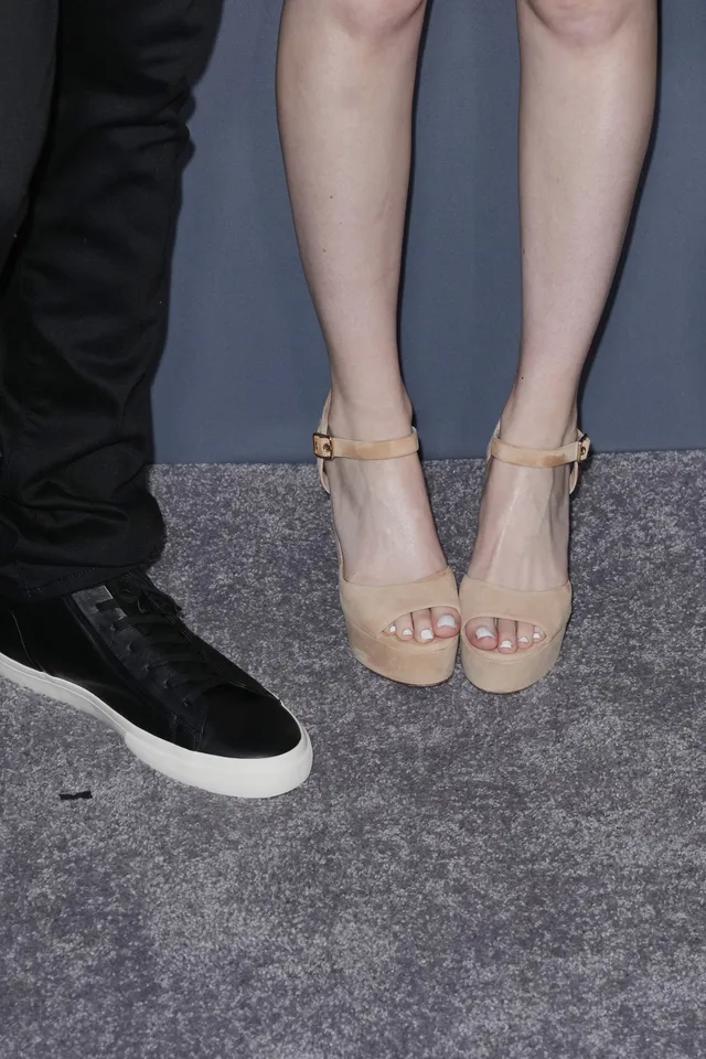 Meg Donnelly shown in a close-up wearing pale ankle-strap heels.