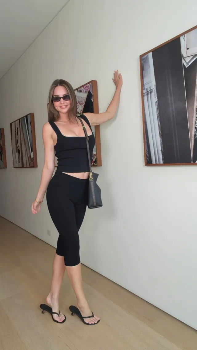 Miranda Kerr a black outfit and flip-flops indoors.