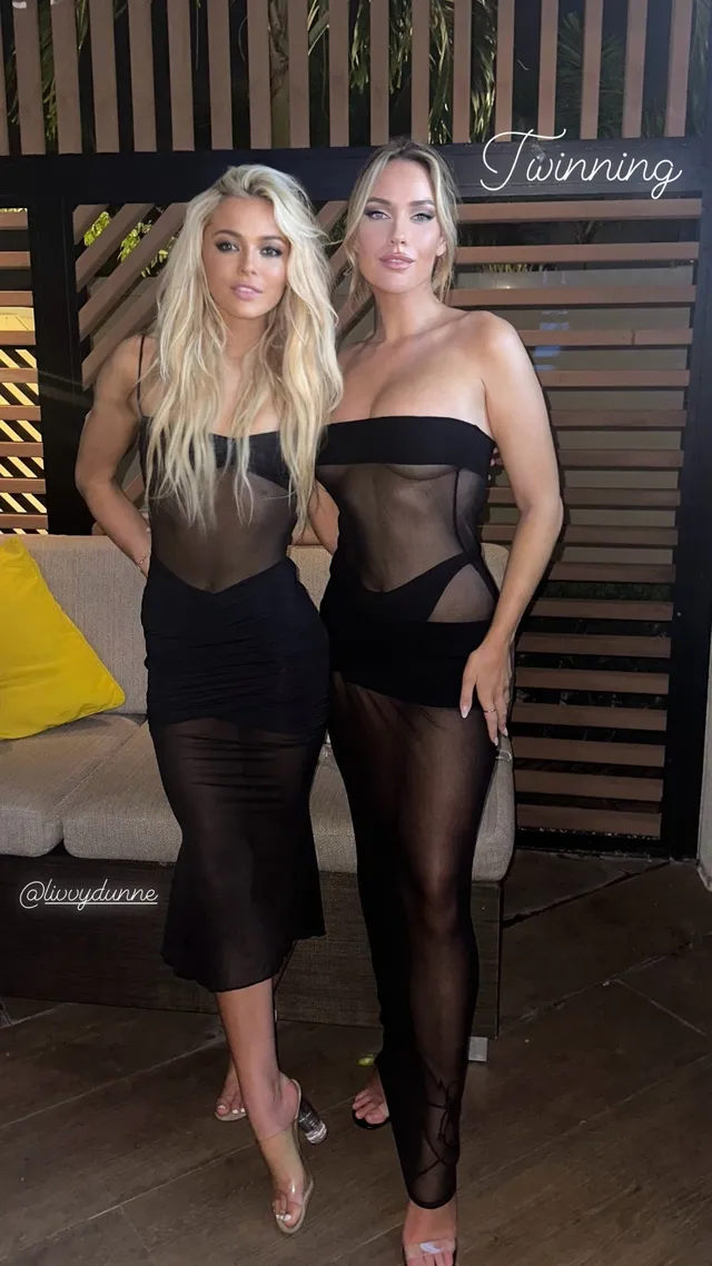 Paige Spiranac posing beside a companion in heeled sandals and a dark outfit.