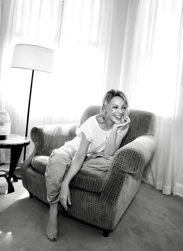 Kylie Minogue a relaxed monochrome portrait in a chair.
