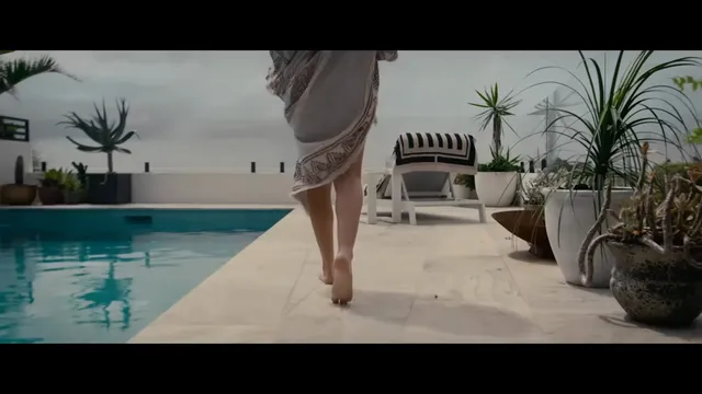 Teresa Palmer walking beside a swimming pool during a screen scene.