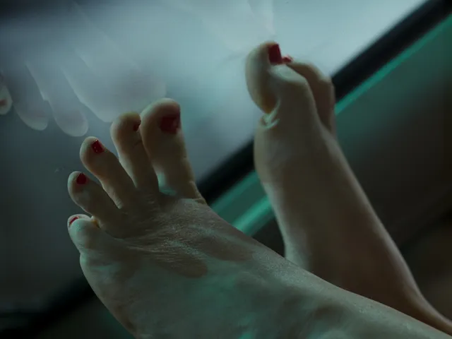 Jennifer Lawrence showing a bare foot in a close-up screen scene.