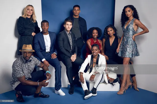 Samantha Logan posing with fellow performers in a patterned dress and heels.