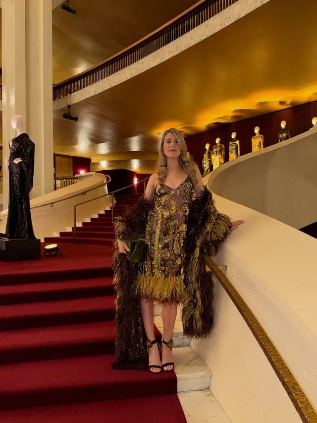 Eugenie Bouchard wearing black heeled sandals and a patterned dress on a staircase.