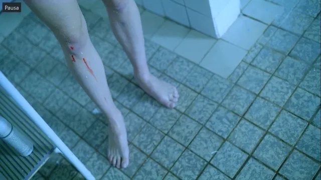 Sophie Turner showing bare feet on a tiled floor in a film scene.