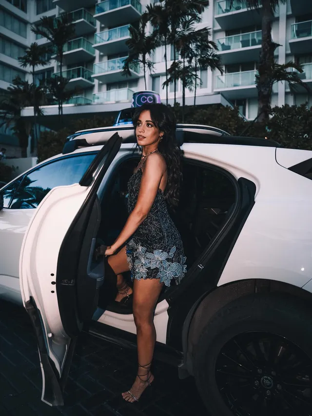 Camila Cabello stepping from a white car wearing a floral outfit.