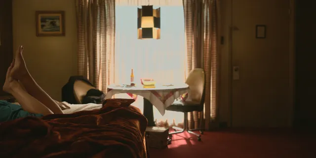 Elizabeth Olsen resting on a sofa in a sunlit screen scene.