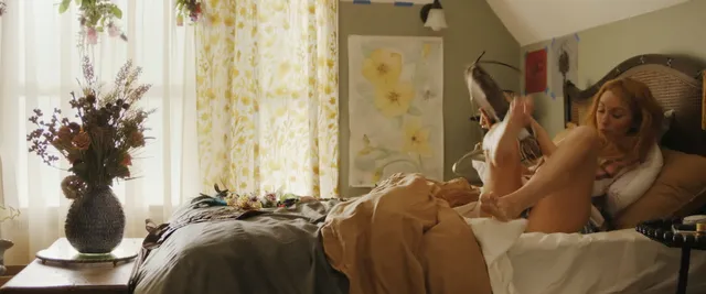 Blake Lively reclining barefoot on a sofa with feet raised.
