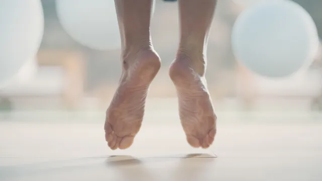 Ana de Armas: close view of bare feet suspended above a floor.