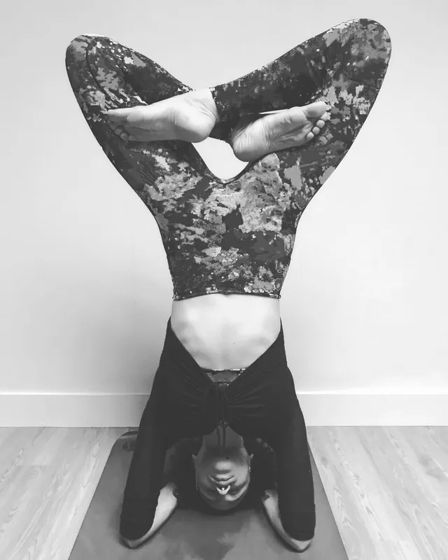 Nathalie Emmanuel balancing upside down in a monochrome exercise photograph.